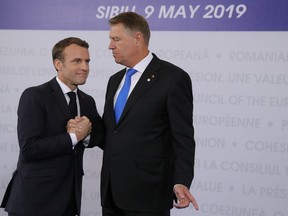 French President Emmanuel Macron, left, is welcomed by Romanian President Klaus Werner Ioannis as he arrives for an EU summit in Sibiu, Romania, Thursday, May 9, 2019. European Union leaders on Thursday start to set out a course for increased political cooperation in the wake of the impending departure of the United Kingdom from the bloc.