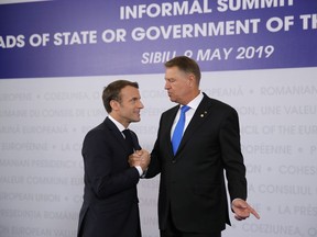 French President Emmanuel Macron, left, is welcomed by Romanian President Klaus Werner Ioannis as he arrives for an EU summit in Sibiu, Romania, Thursday, May 9, 2019. European Union leaders on Thursday start to set out a course for increased political cooperation in the wake of the impending departure of the United Kingdom from the bloc.