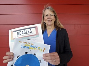 In this photo taken Wednesday, May 15, 2019, Vashon Island High School nurse Sarah Day holds information about measles vaccinations as she poses for a photo in Vashon Island, Wash. Since Day began communal living on Vashon Island more than 20 years ago, the registered nurse has been advocating for getting kids their shots against a loud contingent of anti-vaccine parents in the close-knit community of about 11,000 that's accessible only by ferry, a serene 20-minute ride from Seattle. And it may now be working, thanks to a "perfect storm" of changes being felt on the island, Day said.