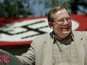 FILE - In this May 22, 2001, file photo, Norm Gissel smiles as he talks about the imminent dismantling of the former headquarters of the Aryan Nations in Hayden Lake, Idaho. Behind Gisel is a Nazi insignia painted atop the roof of the compound's cafeteria. Nearly two decades after the Aryan Nations compound was demolished in Idaho, far-right extremists are maintaining a presence in the Pacific Northwest.