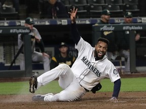 Seattle Mariners' Domingo Santana scores on a walk-off single hit by Omar Narvaez during the 10th inning of a baseball game against the Oakland Athletics, Monday, May 13, 2019, in Seattle. The Mariners won 6-5 in 10 innings.