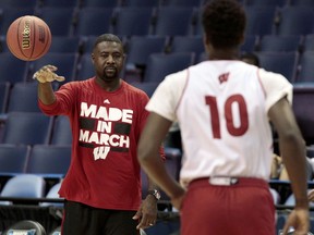 In this March 17, 2016, photo, Wisconsin NCAA college basketball assistant coach Howard Moore, left, passes to forward Nigel Hayes during an open practice at the Scottrade Center in St. Louis, Mo. The University of Wisconsin says the wife and daughter of men's basketball assistant coach Howard Moore were killed in a Michigan automobile accident. Wisconsin's athletic department said Moore's wife, Jennifer, and their daughter, Jaidyn, were killed in the crash on M-14 early Saturday, May 25, 2019, in Washtenaw County's Superior Township. Michigan State Police Lt. Darren Green says Howard Moore suffered third-degree burns but his injuries were not considered life-threatening, and his son had minor injuries.