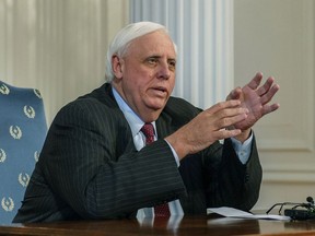 FILE - In this Feb. 19, 2019, file photo, West Virginia Gov. Jim Justice speaks during a press conference at the state Capitol in Charleston, W.Va., after the House of Delegates passed a motion to postpone indefinitely a vote on Senate Bill 451. Justice is a hard man to find. Since he took office as the state's 36th governor a little more than two years ago, he has been criticized for missing key policy debates and rarely being at the statehouse. Some lawmakers suggest he can't focus on governing because he's too busy tending to his business empire, now under intense scrutiny from the federal government.