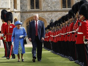 FILE - In this July 13, 2018 file photo, U.S. President Donald Trump with Queen Elizabeth II, inspects the Guard of Honour at Windsor Castle in Windsor, England. Trump's next few weeks will serve as a master's class in the finer points _ and potential pitfalls _ of protocol. He's making state visits to Japan and the United Kingdom where he'll be meeting with both Britain's Queen Elizabeth II and Japan's newly installed Emperor Naruhito.