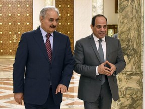 FILE - In this May 9, 2019 file photo, provided by Egypt's presidency media office, Egyptian President Abdel-Fattah el-Sissi, right, walks with Field Marshal Khalifa Hifter, the head of the self-styled Libyan National Army, in Cairo, Egypt. Hifter has hired a lobbying firm to assist it in forging better relations with the U.S. government. A foreign agent registration posted Tuesday on the Justice Department web site shows that the Houston-based Linden Government Solutions is to paid about $2 million over the one-year term of the deal.  (Egyptian Presidency Media office via AP, File)