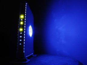 FILE- This July 27, 2008, file photo shows a, LED-illuminated wireless router in Philadelphia. Officials from the United States and Europe are announcing charges against 10 people in connection with malicious software attacks that infected tens of thousands of computers and caused more than $100 million in financial losses.