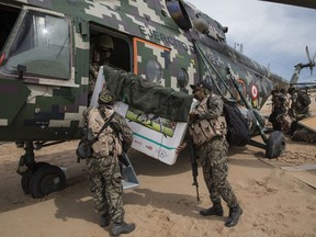 In this April 1, 2019 photo, returning to their home base soldiers load their television in to a military helicopter, on a makeshift airstrip at the Balata military and police base in Peru's Tambopata province.