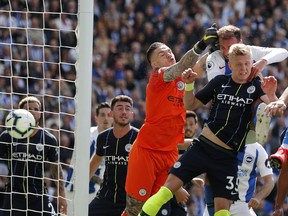 Brighton's Glenn Murray, center right, heads the ball past Manchester City goalkeeper Ederson, center, to score the opening goal during the English Premier League soccer match between Brighton and Manchester City at the AMEX Stadium in Brighton, England, Sunday, May 12, 2019.