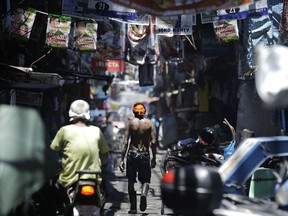 In this Thursday, May 9, 2019, photo, a man walks past election banners in the slum district of Tondo, Manila, Philippines. Philippine President Rodrigo Duterte's name is not on the ballot but Monday's mid-term elections are seen as a referendum on his phenomenal rise to power, marked by his gory anti-drug crackdown and his embrace of China.