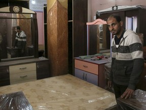 In this April 21, 2019 photo, Palestinian groom Yehiya Taleb, chooses his wedding furniture before his wedding, at a furniture workshop in Gaza City. Hundreds of young men in the Gaza Strip have turned to a small industry of lenders to help them pay for their weddings. Taleb got a job working as a waiter at a cafe earning about $180 a month, but that amount was not enough to cover wedding expenses so he took out a $2,000 package through the Farha Project, one of the wedding financing companies.