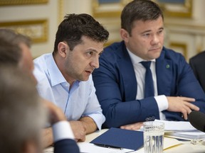Ukrainian president Volodymyr Zelenskiy speaks during a meeting with the lawmakers in Kiev, Ukraine, Tuesday, May 21, 2019. Zelenskiy dropped a bombshell when he said he is dissolving the parliament, dominated by allies of the former Ukrainian president. Zelenskiy sat down with political leaders Tuesday morning to discuss the dissolution. Andriy Bohdan, adviser to Volodymyr Zelenskiy is at right. (Ukrainian Presidential Press Office via AP)
