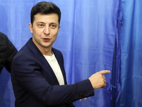 FILE - In this Sunday, April 21, 2019 file photo, Ukrainian comedian and presidential candidate Volodymyr Zelenskiy gestures at a polling station, during the second round of presidential elections in Kiev, Ukraine. Volodymyr Zelenskiy, who takes the presidential oath on Monday May 20, 2019, comes into the post having never held political office; his popularity is rooted in playing the role of president on a television sit-com.