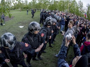 Police officers block demonstrators protesting plans to construct a cathedral in a park in Yekaterinburg, Russia, Tuesday, May 14, 2019. A group that monitors police actions and political repression in Russia says at least 12 people have been detained in Russia's fourth-largest city while protesting plans to start construction of a cathedral in a city park.