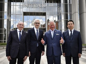 FILE - In this May 8, 2018, file photo, Britain's Prince Charles, the Prince of Wales, second right, poses for photographers with French Interior Minister Gerard Collomb, left, the president of Interpol Meng Hongwei, right, and secretary general of Interpol, Jurgen Stock, during a visit at the Interpol general secretariat headquarters in Lyon, France. Chinese prosecutors on Friday, May 10, 2018, indicted former Interpol president Meng Hongwei on charges of accepting bribes, the latest development in a case that began with his disappearance while on a journey to Beijing.