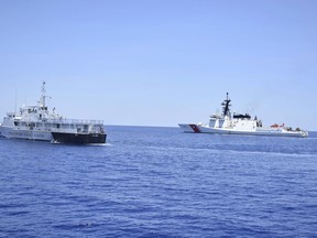 In this May 14, 2019, photo, photo provided by the Philippine Coast Guard, U.S. Coast Guard Cutter Bertholf, right, and Philippine counterpart BRP Batangas conduct joint search and rescue and capability-building exercises off the South China Sea west of the Philippines. Captain John Driscoll, commanding officer of the U.S. Coast Guard National Security Cutter Bertholf (WMSL 750), told reporters Wednesday, May 15, 2019, two Chinese Coast Guard ships were spotted off the South China Sea while they were conducting the joint exercise with Philippine Coast Guard. (Philippine Coast Guard Via AP)