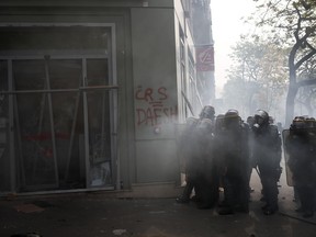 Police officers take position in front of a bank entrance during a May Day rally in Paris, Wednesday, May 1, 2019. Brief scuffles between police and protesters have broken out in Paris as thousands of people gather for May Day rallies under tight security measures. Police used tear gas to control the crowd gathering near Paris' Montparnasse train station.