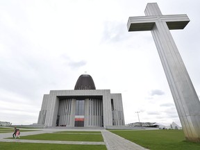 People walk by the Temple of Divine Providence, a major church in the Polish capital,in Warsaw, Poland, Monday, May 13, 2019. A new documentary about pedophile priests has deeply shaken Poland, one of Europe's most Roman Catholic societies, eliciting an apology from the church hierarchy and prompting one priest to leave the clergy.