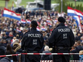 Austrian police officers observe as thousands of mourners gather for a liturgical service in Bleiburg, Austria, Saturday, May 18, 2019. Thousands of Croatian far-right supporters have gathered in a field in southern Austria to commemorate the massacre of pro-Nazi Croats by communists at the end of World War II.