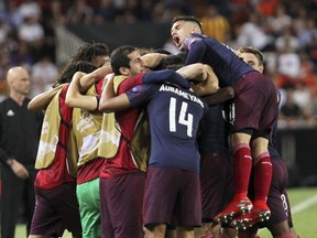 Arsenal players celebrate after forward Alexandre Lacazette scoried his side's second goal during the Europa League semifinal soccer match, second leg, between Valencia and Arsenal at the Camp de Mestalla stadium in Valencia, Spain, Thursday, May 9, 2019.