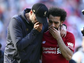 Liverpool manager Juergen Klopp, left, talks to Liverpool's Mohamed Salah at the end of the English Premier League soccer match between Liverpool and Wolverhampton Wanderers at the Anfield stadium in Liverpool, England, Sunday, May 12, 2019. Despite a 2-0 win over Wolverhampton Wanderers, Liverpool missed out on becoming English champion for the first time since 1990 because title rival Manchester City beat Brighton 4-1.