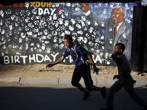 FILE - In this June 13, 2013, file photo, students walk in front of a mural outside the former home of Nelson Mandela, the first black president of South Africa, in Alexandra township in Johannesburg. Twenty-five years after the end of apartheid, inequality is still on display in South Africa. The frustration could play out as the country holds a national election on Wednesday, May 8, 2019.