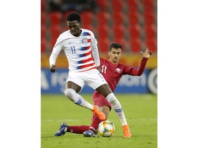 United States' Tim Weah, front, duels for the ball with Qatar's Abdulla Nasser during the Group D U20 World Cup soccer match between USA and Qatar, in Tychy, Poland, Thursday, May 30, 2019.