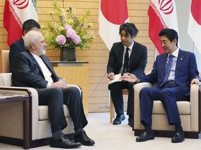 Iranian Foreign Minister Mohammad Javad Zarif, left, and Japanese Prime Minister Shinzo Abe, right, speak at Abe's official residence in Tokyo Thursday, May 16, 2019. Iran's foreign minister has said his country is committed to an international nuclear deal and criticized escalating U.S. sanctions "unacceptable" as he met with Japanese officials in Tokyo amid rising tensions in the Middle East.