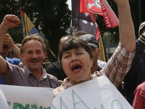 Supporters of president-elect Volodymyr Zelenskiy cheer in front of the parliament building in Kiev, Ukraine, Thursday, May 16, 2019, after parliament voted to swear in the new president on May 20. Posters read: "We need May 19". Ukraine's parliament has voted to swear the new president into office next week, opening the possibility of a snap parliamentary election.