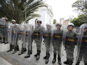 Venezuelan Bolivarian National guards officers form a cordon around the National Assembly building as the opposition-controlled congress met to discuss a move that could provide political cover for greater international involvement in the nation's crisis, in Caracas, Venezuela, Tuesday, May 7, 2019. Military police prevented journalists from entering the National Assembly, and some reporters were harassed by government supporters outside the building.