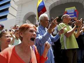 Demonstrators shout slogans against Venezuela's President Nicolas Maduro outside the Venezuelan Red Cross headquarters where protesters gathered to demand humanitarian aid in Caracas, Venezuela, Wednesday, May 29, 2019. Demonstrators protested the deaths of several children with leukemia who were awaiting bone marrow transplants, which has ignited a bitter dispute between the government and opponents over who is to blame.