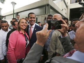 Venezuela's opposition leader and self-proclaimed interim president Juan Guaido, center, poses for a selfie photo with supporters after a meeting of "Plan Pais" or Country Plan at University Catholic Andres Bello in Caracas, Venezuela, Friday, May 24, 2019.