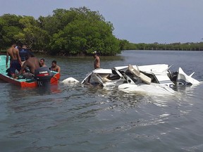 In this photo released by the Honduras Fire Department, firefighters and men work at the crash site of a plane that fell into the Atlantic in Roatan, Bay Island, Honduras, Saturday, May 18, 2019. All five people on board were killed after the plane plummeted shortly after takeoff from the popular tourist destination of Roatan en route to the port of Trujillo.