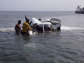 In this photo released by the Honduras Fire Department, firefighters work at the crash site of a plane that fell into the Atlantic near Roatan, Bay Island, Honduras, Saturday, May 18, 2019. All five people on board were killed after the plane plummeted shortly after takeoff from the popular tourist destination of Roatan en route to the port of Trujillo. (Honduras Fire Department via AP)