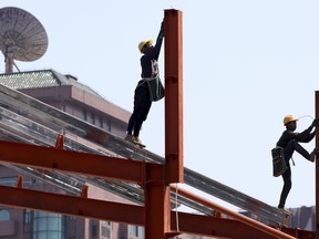 Workers labor in downtown Beijing on Thursday, May 9, 2019. The U.S. effort to win concessions from China on strategic industrial policies has put the Chinese President Xi Jinping's own prestige on the line. It also has cast into question the ruling Communist Party's social contract with the Chinese people: keeping authoritarian, one-party rule and ruling class privileges in exchange for delivering robust economic growth, better living standards and a higher global profile for China.