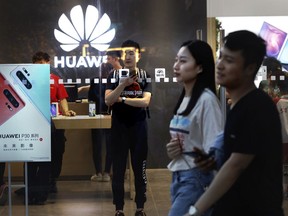 In this Monday, May 20, 2019, photo,  shoppers visit a Huawei store in Beijing. Chinese tech giant Huawei has filed a motion in U.S. court challenging the constitutionality of a law that limits its sales of telecom equipment.