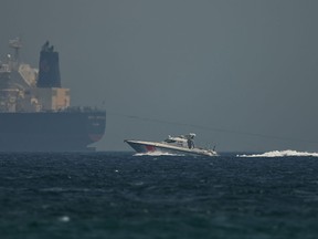 An Emirati coast guard vessel passes an oil tanker off the coast of Fujairah, United Arab Emirates, Monday, May 13, 2019. Saudi Arabia said Monday two of its oil tankers were sabotaged off the coast of the United Arab Emirates near Fujairah in attacks that caused "significant damage" to the vessels, one of them as it was en route to pick up Saudi oil to take to the United States.