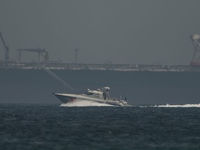 An Emirati coast guard vessel passes an oil tanker off the coast of Fujairah, United Arab Emirates, Monday, May 13, 2019. Saudi Arabia said Monday two of its oil tankers were sabotaged off the coast of the United Arab Emirates near Fujairah in attacks that caused "significant damage" to the vessels, one of them as it was en route to pick up Saudi oil to take to the United States.