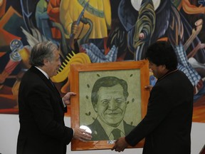 Secretary General of the Organization of American States Luis Almagro, left, receives a portrait of himself designed with painted coca leaves, from Bolivia's President Evo Morales, at the government palace in La Paz, Bolivia, Friday, May 17, 2019. Almagro is in Bolivia on an official visit.
