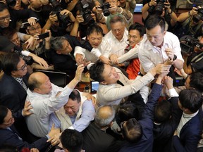 Pro-democracy and pro-Beijing lawmakers scuffle in the chamber at Legislative Council in Hong Kong.