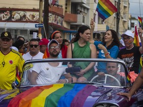 FILE - In this May 12, 2018 file photo, Mariela Castro, daughter of Raul Castro and director of Cuba's National Center for Sexual Education, waves a rainbow flag while sitting in a convertible car during the annual Gay Pride parade in Havana, Cuba. Castro said Tuesday, May 7, 2019, that the Cuban government has cancelled the Conga Against Homophobia parade, that was widely seen as a sign of progress on gay rights.