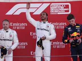Mercedes driver Lewis Hamilton of Britain, center, celebrates on the podium after winning the Spanish Formula One race, flanked by second place Mercedes driver Valtteri Bottas of Finland, left and third place Red Bull driver Max Verstappen of the Netherland's, at the Barcelona Catalunya racetrack in Montmelo, just outside Barcelona, Spain, Sunday, May 12, 2019.