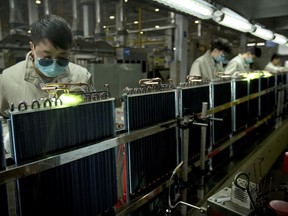 In this Feb. 24, 2017, photo, factory workers use gas torches on air conditioning condenser units on an assembly line at a Haier factory in Jiaozhou near Qingdao in eastern China's Shandong Province. U.S. President Donald Trump's latest tariff hike on Chinese goods took effect Friday, May 10, 2019, and Beijing said it would retaliate, escalating a battle over China's technology ambitions and other trade tensions.