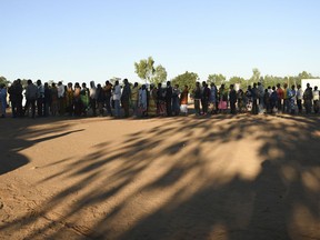 People queue to cast their votes near Blantyre, Malawi, Tuesday, May 21, 2019. Voting is underway to elect a new president in which 78-year-old President Peter Mutharika is seeking re-election to a second term.