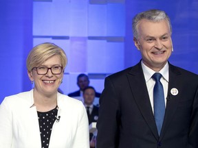 In this photo taken on Wednesday, May 8, 2019, Economist Gitanas Nauseda and Former finance minister Ingrida Simonyte, left, a presidential candidates, pose for the media prior to the start of the televised live debate in Vilnius, Lithuania. Gitanas Nauseda and a former finance minister Ingrida Simonyte held the top two spots in returns from Lithuania's presidential election Sunday, May 26 and appeared headed to a runoff ballot later this month to choose a successor to incumbent Dalia Grybauskaite.