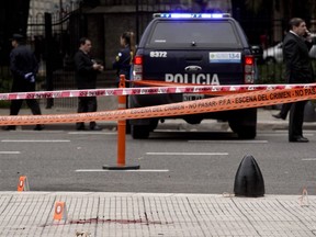 CORRECTS TO CHANGE FROM MOVING VEHICLE TO PARKED CAR - Police stand near the crime scene where Argentine lawmaker Hector Olivares was seriously injured and another man killed after they were shot at from a parked car near the congressional building, in Buenos Aires, Argentina, Thursday, May 9, 2019. Officials say that lawmaker Héctor Olivares was shot at around 7 a.m. local time. Olivares is a representative of La Rioja province in Argentina's lower house of Congress. He is being treated at a hospital in Buenos Aires.