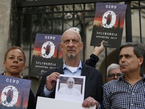 Members of the organization called Ending Clergy Abuse, Denise Buchanan, left, and Peter Isely, center, stand with Sebastian Cuattromo, a victim of sexual abuse at a religious school when he was a youth by a teacher who was found guilty, as they stand outside a church in Buenos Aires, Argentina, Thursday, May 2, 2019. The three are demanding Pope Francis "zero tolerance" regarding abuse and an end to what they see as cover ups by members of the church.