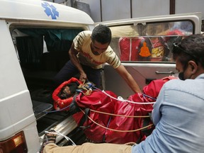Hospital officials unload a dead body of an Indian mountaineer after the same was brought to Teaching hospital in Kathmandu, Nepal, Sunday, May 19, 2019. Two mountaineers died on Nepal's famous Himalayan peaks, while another two climbers were missing, officials said Friday.