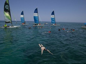 In this May 12, 2019 photo, tourists snorkel in the Caribbean, off a beach in Varadero, Cuba. As most of Cuba's economy stagnates or declines, the country has launched a full-scale effort to turn virtually the only bright spot, tourism, into an engine that can drag the rest of the communist island through its worst economic crisis in two decades.