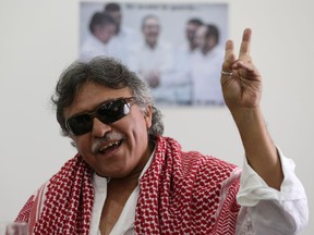 FILE - In this Dec. 6, 2016 file photo, Revolutionary Armed Forces of Colombia, FARC, rebel commander and peace negotiator Seuxis Hernandez, alias Jesus Santrich, flashes a victory hand signal at the end of a press conference in Bogota, Colombia. The Special Peace Tribunal investigating crimes during the country's long civil conflict announced Wednesday, May 15, 2019, that Hernandez, should not be extradited to the United States on a drug warrant.