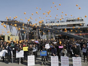 FILE - In this March 16, 2016, file photo, Officials of South Korean firms with plants in the now-suspended inter-Korean factory complex in North Korea's border town of Kaesong, release balloons during a rally at the Imjingak pavilion near the border village of Panmunjom in Paju, South Korea. The letters at banners read " Make Kaesong Industrial Complex to resume".